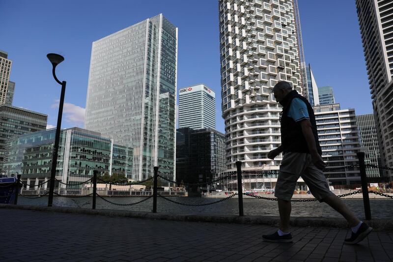 A pedestrian passes the HSBC Holdings Plc headquarters office building, centre, in the Canary Wharf business, financial and shopping district of London, UK  Bloomberg