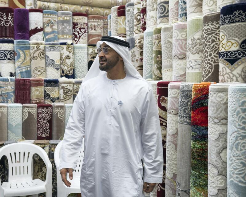 ABU DHABI, UNITED ARAB EMIRATES -  February 22, 2018: HH Sheikh Mohamed bin Zayed Al Nahyan, Crown Prince of Abu Dhabi and Deputy Supreme Commander of the UAE Armed Forces (C), visits the carpet market in the Mina Zayed Port area. 
( Ryan Carter for the Crown Prince Court - Abu Dhabi )
---