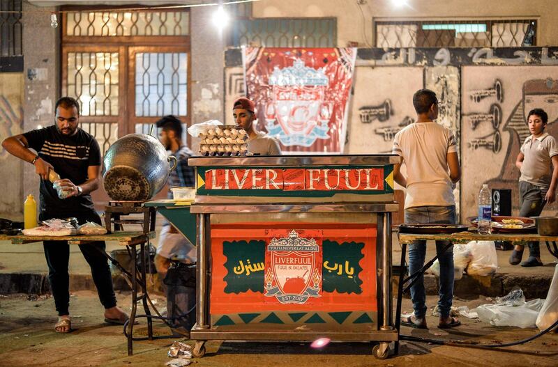 Egyptians cook food during the pre-dawn suhoor meal before a new day of fasting begins near a food cart by the name "Liver Fuul", a play on Arabic name for fava beans and English football club Liverpool FC, in the Ain Shams suburb of northeastern Cairo. AFP