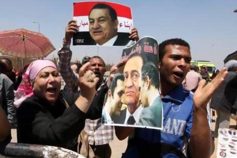 Supporters hold portraits of Hosni Mubarak outside the Police Academy in Cairo on Monday. Khaled Elfiqi / EPA