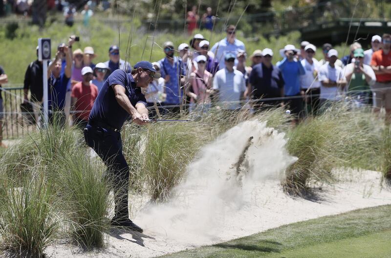 Phil Mickelson of the US hits out of the sand on the first hole during his first round 70. EPA