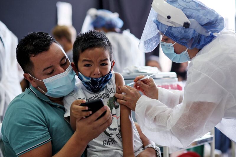 A health worker inoculates a boy at a vaccination centre in Bogota, Colombia. AFP