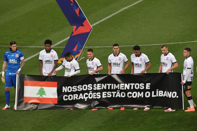 Brazil's Corinthians players hold banner "Our feelings and hearts are with Lebanon" before their football match against Palmeiras.  AFP