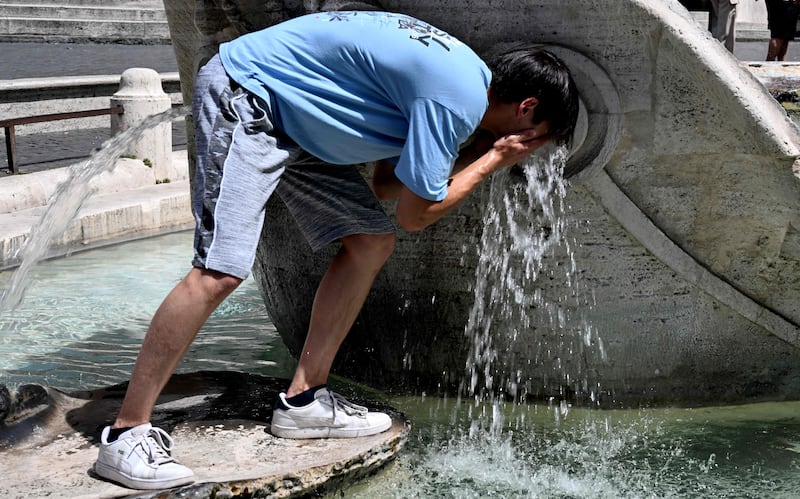 A boy cools down at the Barcaccia fountain in Rome. AFP