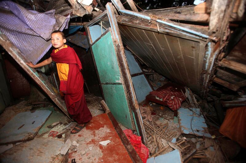 A young Buddhist monk stands near the rubble at Enchey Monastery in Gangtok, India, Tuesday, Sept. 20, 2011. Thousands of terrified survivors of a Himalayan earthquake that killed many people and shook parts of India, Nepal and China crowded Tuesday into shelters and relatives' homes or stayed out in the open for fear of aftershocks. (AP Photo/Anupam Nath) *** Local Caption ***  India Earthquake.JPEG-06efc.jpg