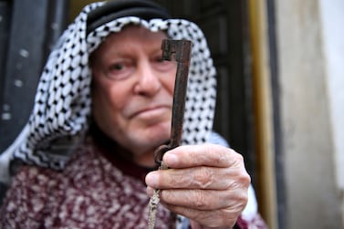 An old Palestinian man holds a key symbolizing his old home as he marks the 74th anniversary of Nakba in Fawwar refugee camp, south of the West Bank city of Hebron, 15 May 2022.  Nakba Day, or Day of the Catastrophe, is marked on 15 May to commemorate the expulsion of more than 700,000 Palestinians from their land in the war surrounding the establishment of the state of Israel in 1948.   EPA / ABED AL HASHLAMOUN