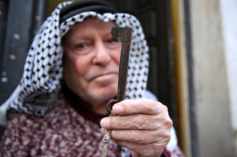 An old Palestinian man holds a key of his old home as he marks the 74th anniversary of Nakba in Fawwar refugee camp, south of the West Bank city of Hebron, on May 15, 2022. EPA