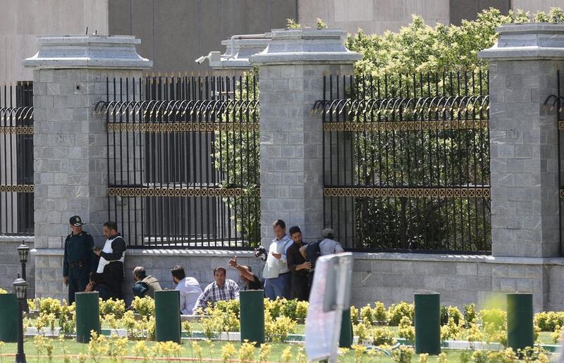 Members of Iranian forces and people take cover during a gun attack at the parliament’s building in central Tehran. Tima via Reuters