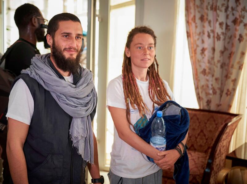 Italian Luca Tacchetto and Canadian Edith Blais are greeted by officials as they arrive at the airport in Bamako on March 14, 2020 after their release by UN peacekeepers. AFP