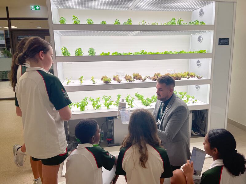 A teacher with pupils in the hydroponics room at The Royal Grammar School Guildford Dubai.