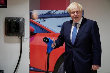 Britain's Prime Minister Boris Johnson holds an electric vehicle charging cable as he visits the headquarters of Octopus Energy, in London, Britain October 5, 2020. Leon Neal/Pool via REUTERS