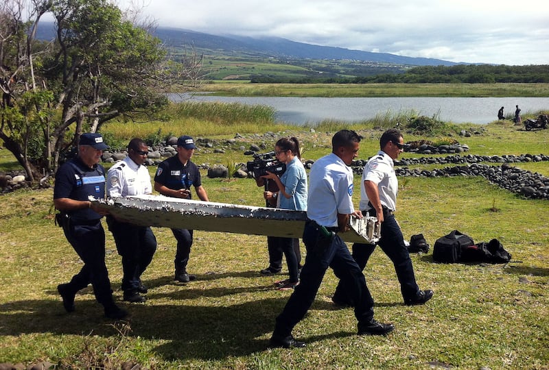 Police carry a piece of debris found in Saint-Andre de la Reunion on July 29, 2015. AFP