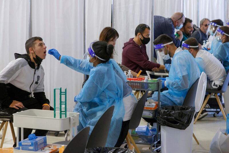 Vaccinated Israelis and tourists get tested for COVID-19 upon arrival to Israel's Ben Gurion airport near Tel Aviv on May 23, 2021, after a partial re-opening of the border to inoculated tourists from 14 countries. / AFP / JACK GUEZ
