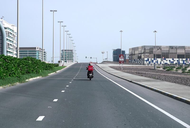Abu Dhabi, United Arab Emirates, April 5, 2020.  A lone Zomato delivery man crosses the Al Bandar overpass at Khalifa City.
Victor Besa / The National
Section:  NA
Reporter: