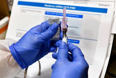 FILE - In this July 27, 2020, file photo, nurse Kathe Olmstead prepares a shot that is part of a possible COVID-19 vaccine, developed by the National Institutes of Health and Moderna Inc., in Binghamton, N.Y. Moderna said Monday, Nov. 16, 2020, its COVID-19 shot provides strong protection against the coronavirus that's surging in the U.S. and around the world. (AP Photo/Hans Pennink, File)