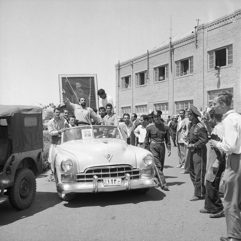 A portrait of the Shah of Iran is carried through the streets of Tehran by followers of the monarch, as he makes his return to the capital after a brief exile, in August 1953. Photo: Bettmann Archive