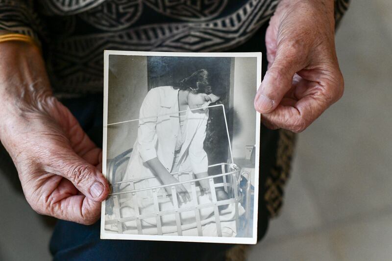 Dr Rafeeya Sultan Pasha holds an photograph of her working as a gynecologist in Karachi. Khushnum Bhandari / The National