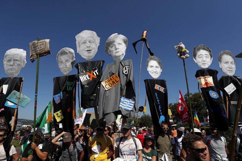Protestors hold portraits representing G7 leaders on the opening day of the G7 summit.  EPA