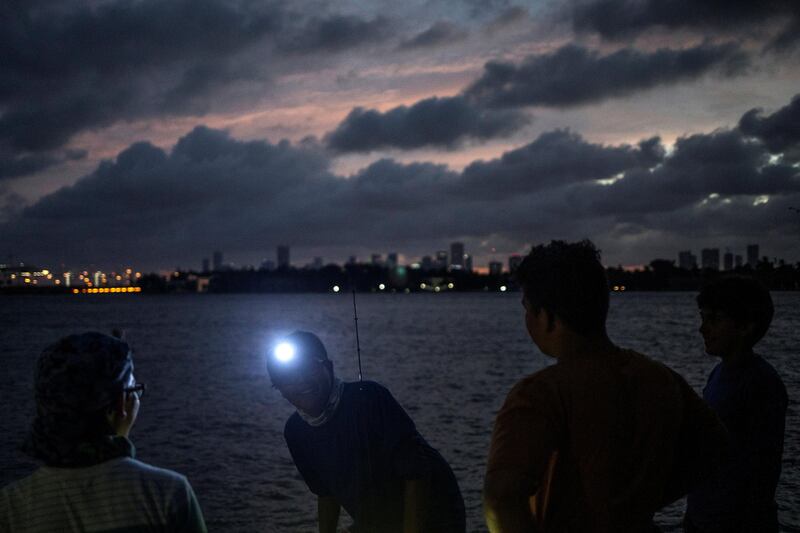 The Miami skyline is seen in the background as boys fish ahead of the arrival of Hurricane Irma in Miami Beach, Florida. Adrees Latif / Reuters