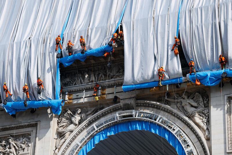 Workers unravel silver-blue fabric. AFP