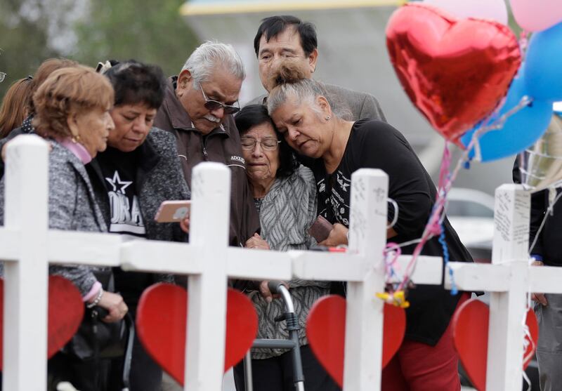 FILE - In this Nov. 10, 2017, file photo, family and friends gather around a makeshift memorial for the victims of the First Baptist Church shooting at Sutherland Springs Baptist Church in Sutherland Springs, Texas. The machete attack on a rabbi's home in Monsey, New York, during Hanukkah and the shooting of worshippers at a Texas church are refocusing attention on how vulnerable worshippers are during religious services. FBI hate crime statistics show there is reason for concern. (AP Photo/Eric Gay, File)