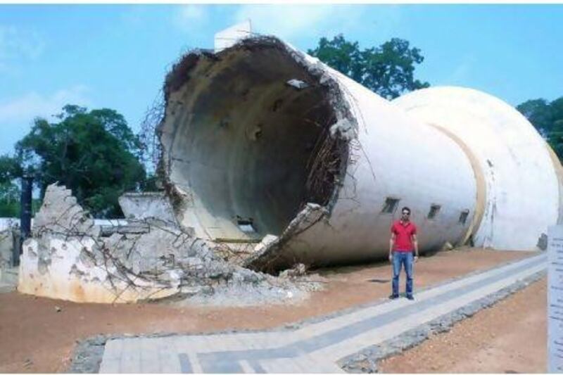 War relics, such as this destroyed water tank in Jaffna, where Mobisher Rabbani stands, have become popular destinations in Sri Lanka. Courtesy of Mobisher Rabbani