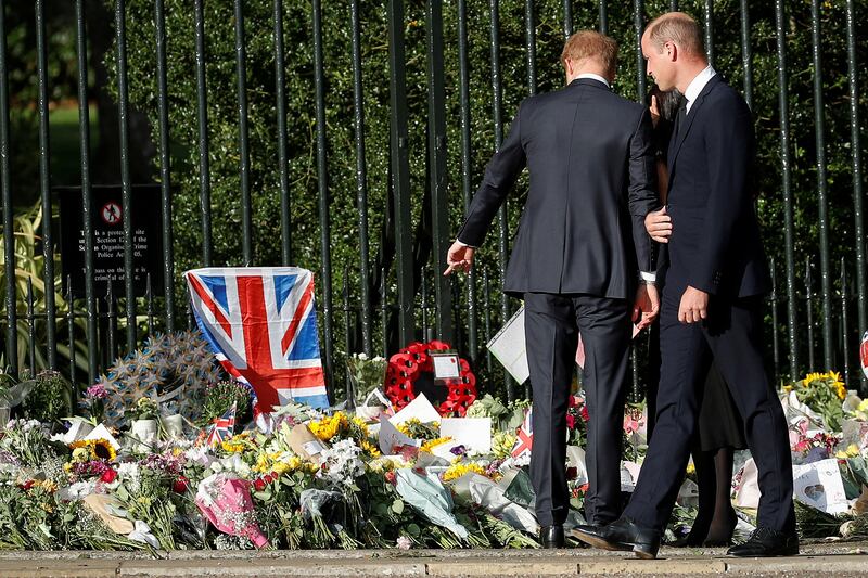 Prince Harry points at a floral tribute. Reuters