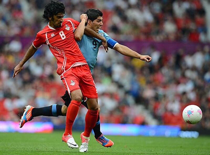 Uruguay's Luis Suarez (R) vies with UAE's Hamdan Al Kamali during their menÕs football match during the London 2012 Olympic Games at Old Trafford in Manchester, north-west England on July 26, 2012. AFP PHOTO / ANDREW YATES

