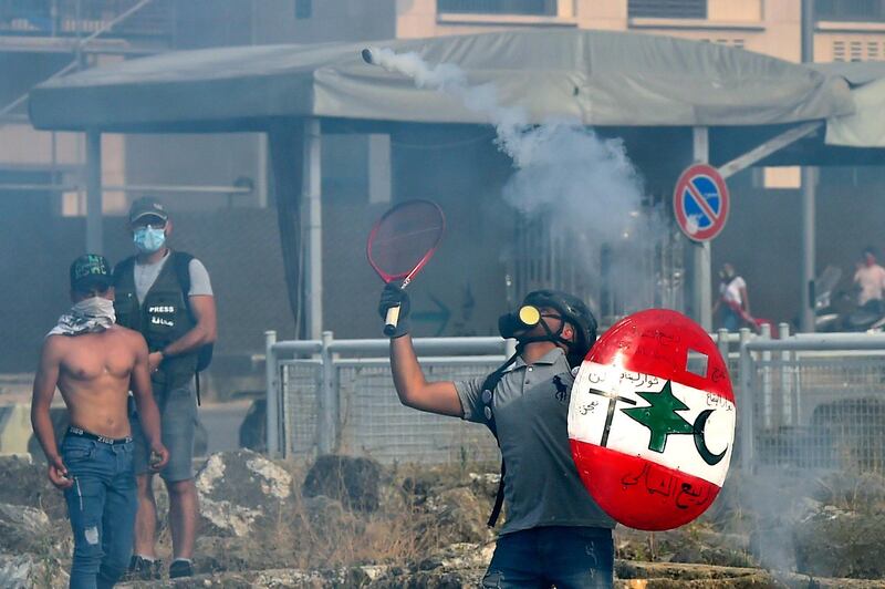 An anti-government protester uses a tennis racket to return a tear gas canister at riot policemen during a demonstration against the Lebanese government and worsening economic conditions in downtown Beirut, Lebanon.  EPA