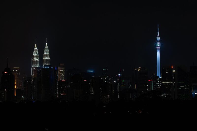 Malaysia: The Petronas Twin Towers, left, and Kuala Lumpur Tower, right, stand illuminated before their lights are turned off to mark Earth Hour. AFP