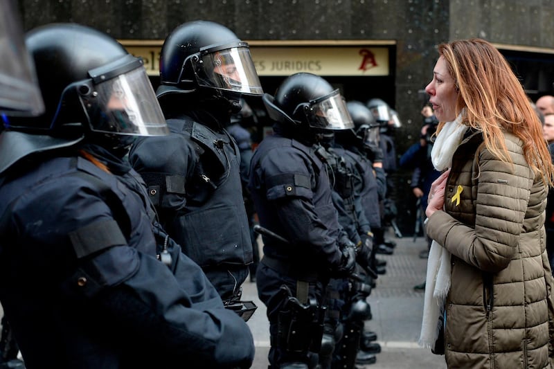 A protester cries as she speaks to riot police blocking the road leading to the central government offices at a demonstration in Barcelona, Spain, on March 25, 2018. Josep Lago / AFP Photo