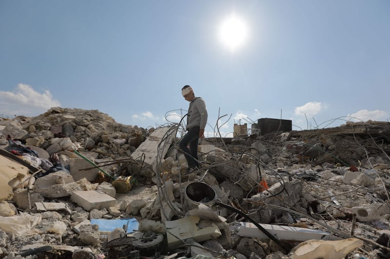 A Syrian boy, who lost his family and was also wounded as a result of the deadly earthquake, wanders amid the rubble of his family home. AFP