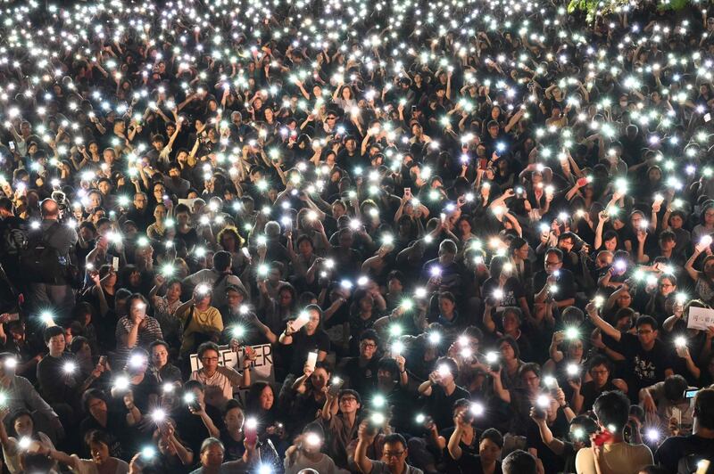 Demonstrators hold up lights from their phones during a rally organised by Hong Kong mothers in support of extradition law protesters, in Hong Kong. AFP