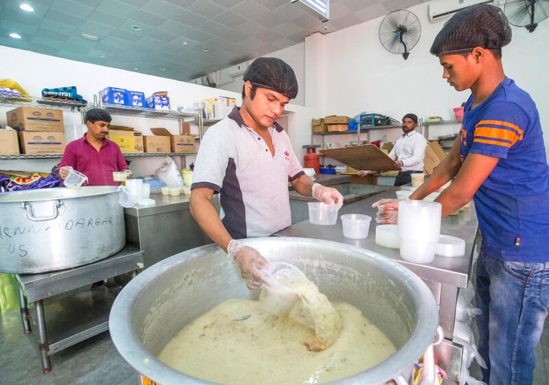 DUBAI,  UNITED ARAB EMIRATES, 20 May 2018 - Staff starts to place the porridge in a small container to serve during iftar at Wonder  Chef Catering, Al Quoz, Dubai. Leslie Pableo for The National  for Ramola Talwar story