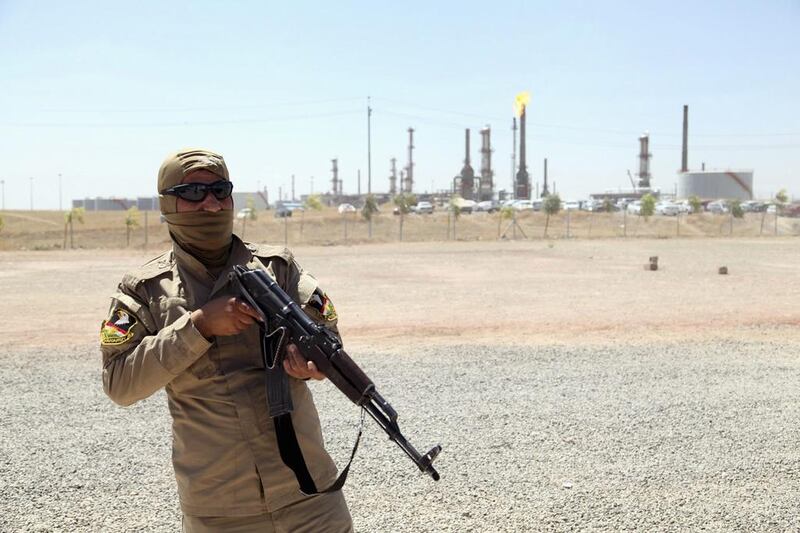 A member of Kurdish security forces takes up position with his weapon as he guards an oil refinery on the outskirts of Mosul,  June 22, 2014. U.S. Secretary of State John Kerry met Iraq's Prime Minister Nuri al-Maliki in Baghdad on Monday to push for a more inclusive government, even as Baghdad's forces abandoned the border with Jordan, leaving the entire Western frontier outside government control. Picture taken June 22, 2014. REUTERS/Azad Lashkari (IRAQ - Tags: CIVIL UNREST POLITICS MILITARY CONFLICT ENERGY TPX IMAGES OF THE DAY)