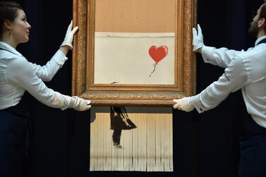 The newly completed work by artist Banksy entitled 'Love is in the Bin' was created when the painting 'Girl with Balloon' was passed through a shredder at Sotheby's auction house in London last year (Photo by Ben STANSALL / AFP) 