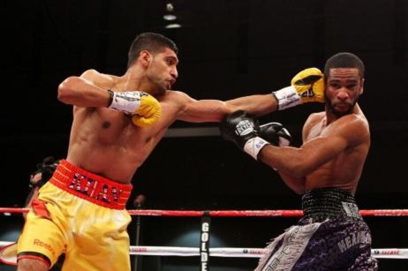 WASHINGTON, DC - DECEMBER 10: Amir Khan punches Lamont Peterson during their WBA Super Lightweight and IBF Junior Welterweight title fight at Washington Convention Center on December 10, 2011 in Washington, DC.   Al Bello/Getty Images/AFP== FOR NEWSPAPERS, INTERNET, TELCOS & TELEVISION USE ONLY ==
 *** Local Caption ***  450685-01-09.jpg