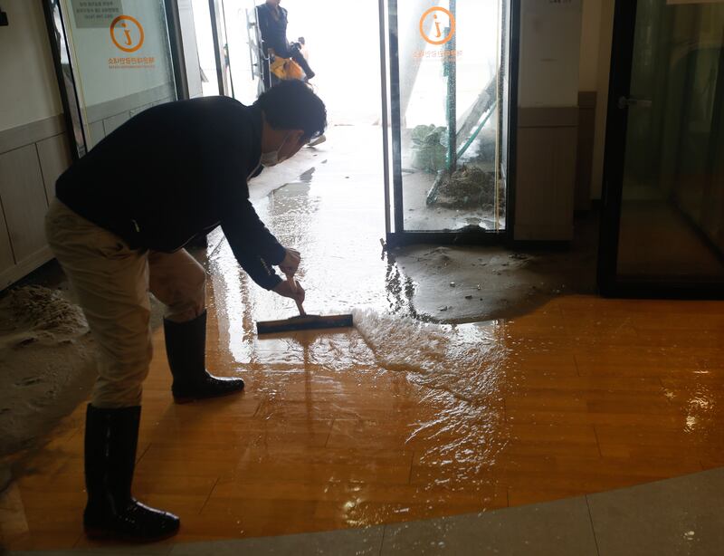 A government worker cleans up in Busan after Typhoon Hinnamnor made landfall. EPA