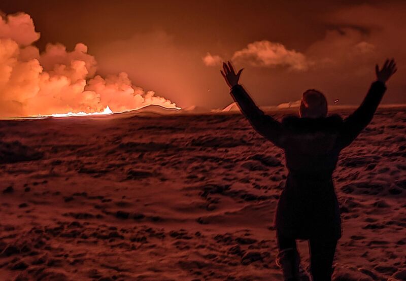 A local resident watches smoke billow as the lava colours the night sky orange on the Reykjanes peninsula. AFP