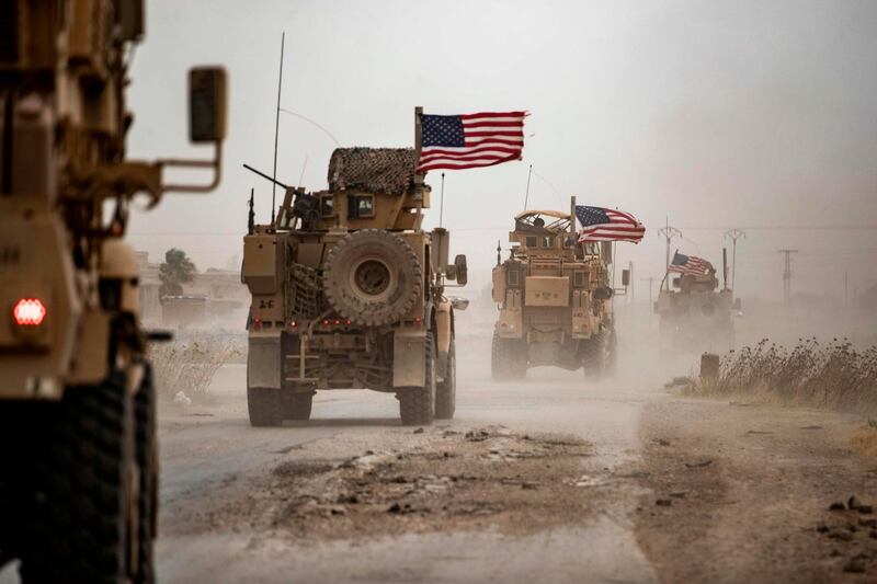 US military vehicles drive in the vicinity of an oil field in Rumaylan (Rmeilan) amid a sandstorm in Syria's kurdish-controlled northeastern Hasakeh province.   AFP