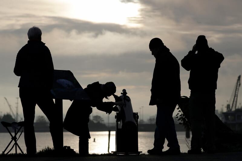 Viewers look on during a brief break in the clouds to see a transit of the planet Mercury. AP Photo