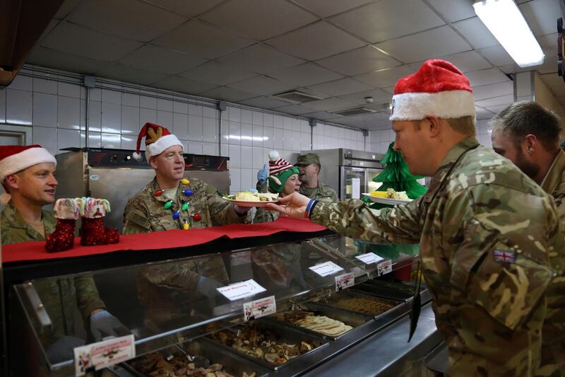Members of the U.S. military are served dinner on Christmas Day at the Resolute Support Headquarters in Kabul, Afghanistan. (AP Photo/Rahmat Gul)