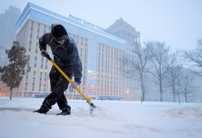 Sam Miller shovels a clear path for people to walk in central St Louis, Missouri, on February 3, 2022. AP