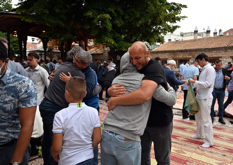 People exchange greetings after early morning prayers in Sarajevo, Bosnia.