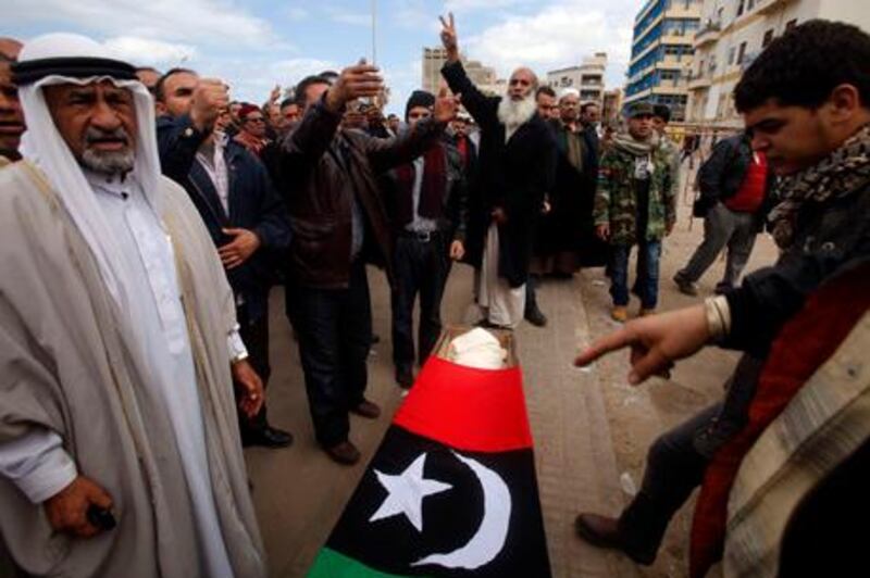 Mourners react next to a coffin containing the body of a rebel killed in Bin Jawad during clashes with forces loyal to Libyan leader Muammar Gaddafi, at his funeral in Benghazi March 10, 2011. REUTERS/Suhaib Salem (LIBYA - Tags: POLITICS CIVIL UNREST) *** Local Caption ***  SJS04_LIBYA-_0310_11.JPG