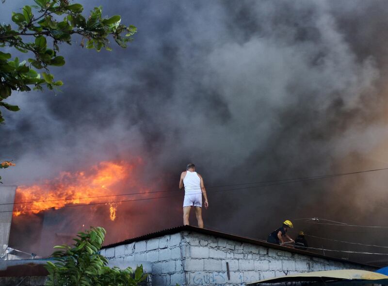 A Filipino resident watches a blaze in Las Pinas, south of Manila.  EPA