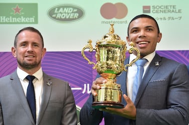 Former World Rugby Players of the Year Bryan Habana of South Africa (R) and Shane Williams of Wales (L) pose with the Webb Ellis Cup during a 100 Day to Go Kick-Off event for the Rugby World Cup 2019 in Tokyo on June 12, 2019. / AFP / Kazuhiro NOGI