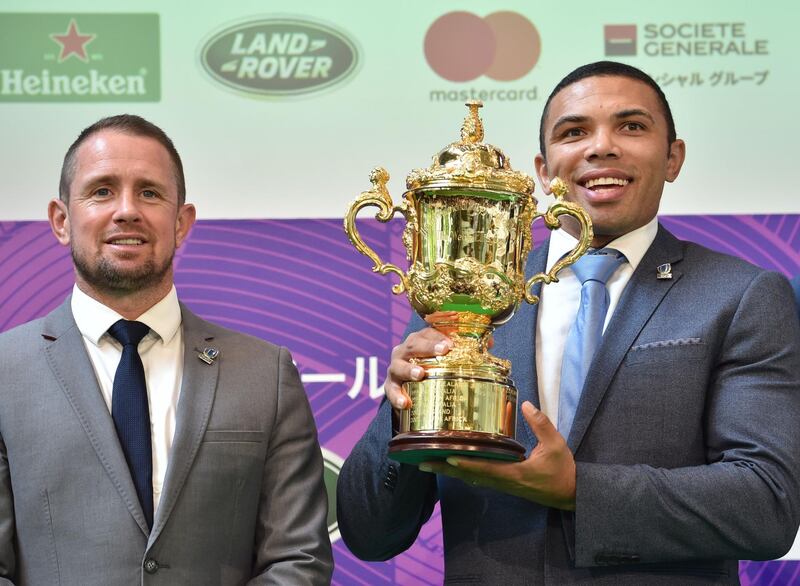 Former World Rugby Players of the Year Bryan Habana of South Africa (R) and Shane Williams of Wales (L) pose with the Webb Ellis Cup during a 100 Day to Go Kick-Off event for the Rugby World Cup 2019 in Tokyo on June 12, 2019.  / AFP / Kazuhiro NOGI
