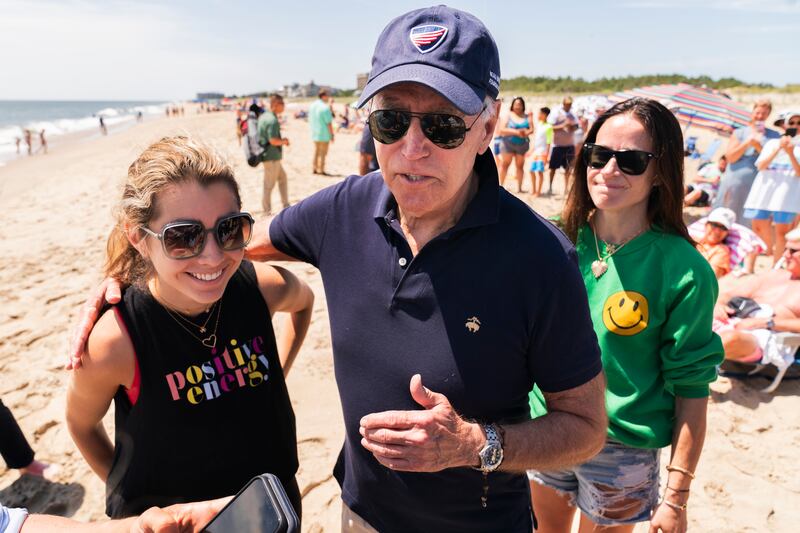Mr Biden introduces his granddaughter to the members of the media as they walk on the beach together with daughter Ashley. AP