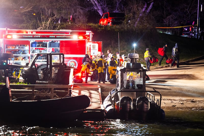 Rescuers gather on the shore of the Patapsco River for an operation authorities described as a 'mass casualty, multi-agency rescue'. EPA